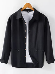 Black long sleeve button-up shirt with two chest pockets, worn over a white tee.