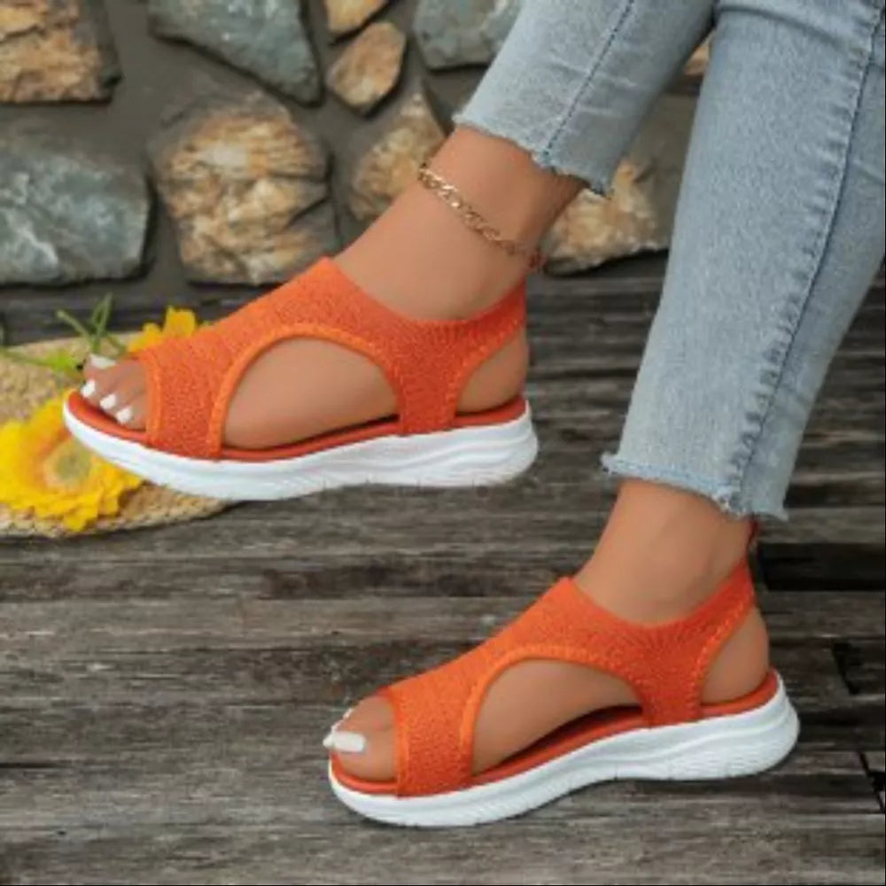 Orange open-toe platform sandals with white soles and elastic straps.