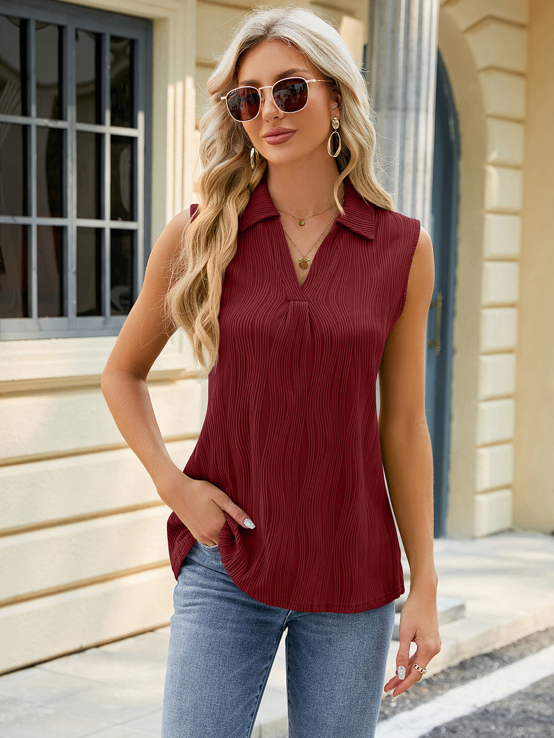 Burgundy textured collared sleeveless blouse with a V-neck and subtle pleating.