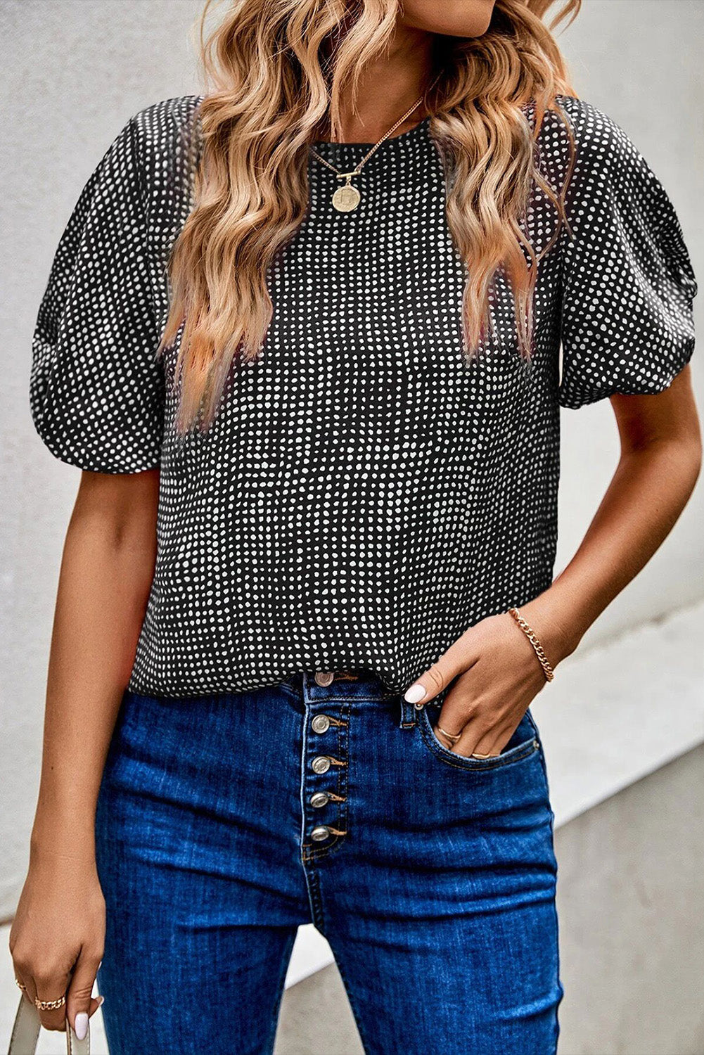 Black dotted puff sleeve blouse with crew neck, styled with blue jeans.