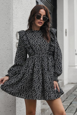 Black dot print dress with ruffle trim, long sleeves, and a cinched waist.