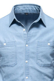 Light blue faded denim utility shirt with two chest pockets and white buttons.
