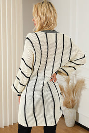 Ivory knit oversized V-neck dress with black vertical stripes and waffle texture.