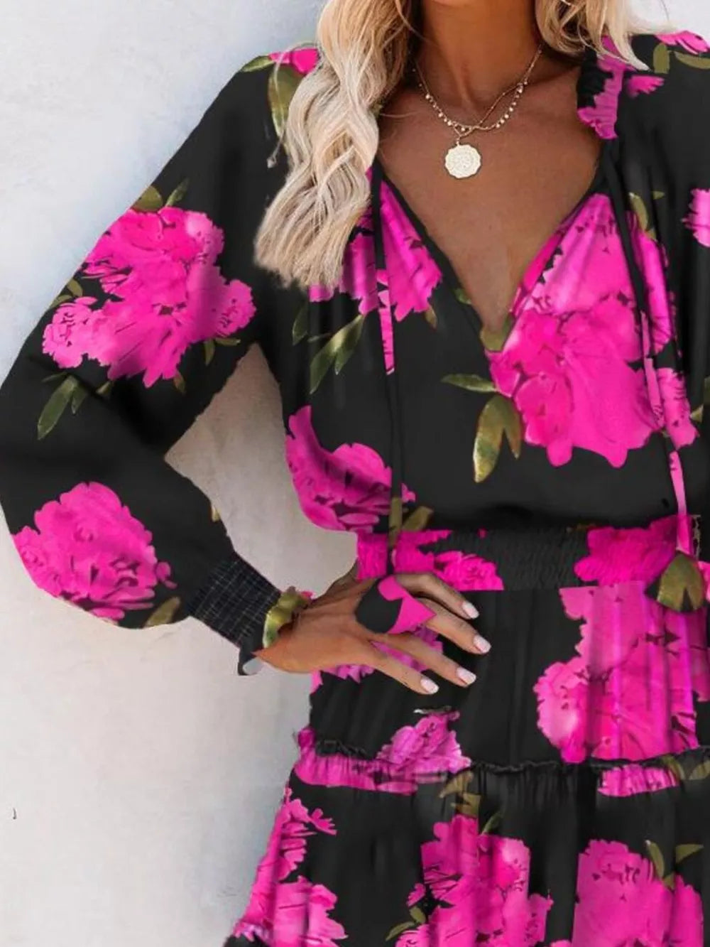 Pink floral tiered dress with long sleeves, V-neck, and smocked waist.