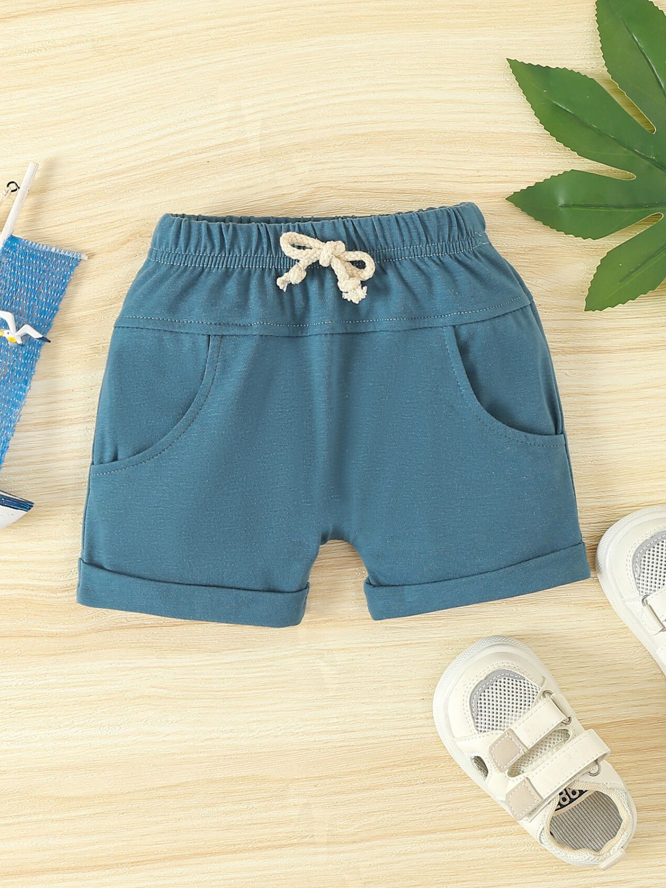 Sky blue cotton shorts with drawstring and cuffed hem.