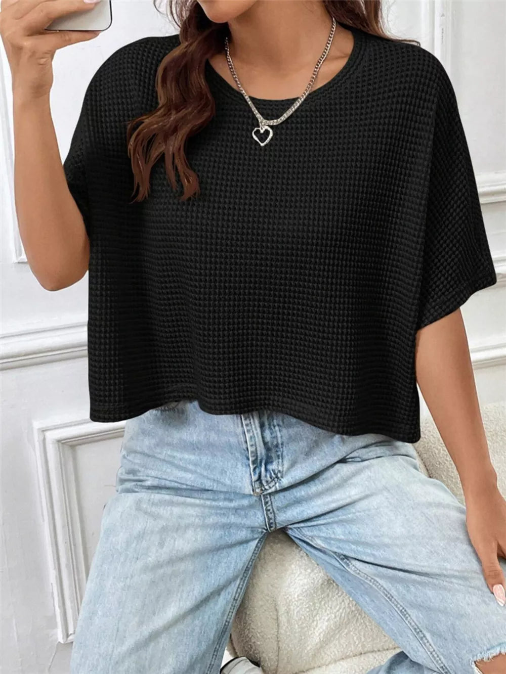 Black waffle-knit cropped t-shirt with crew neck and short sleeves.