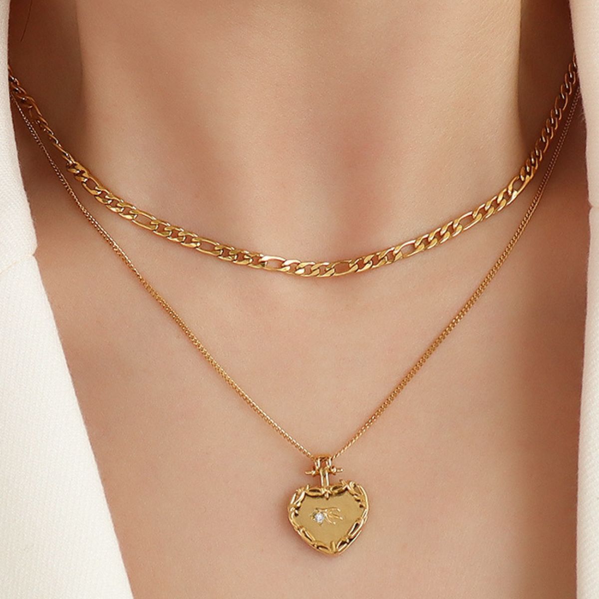 Gold layered necklace with figaro chain and heart locket pendant with diamond accent
