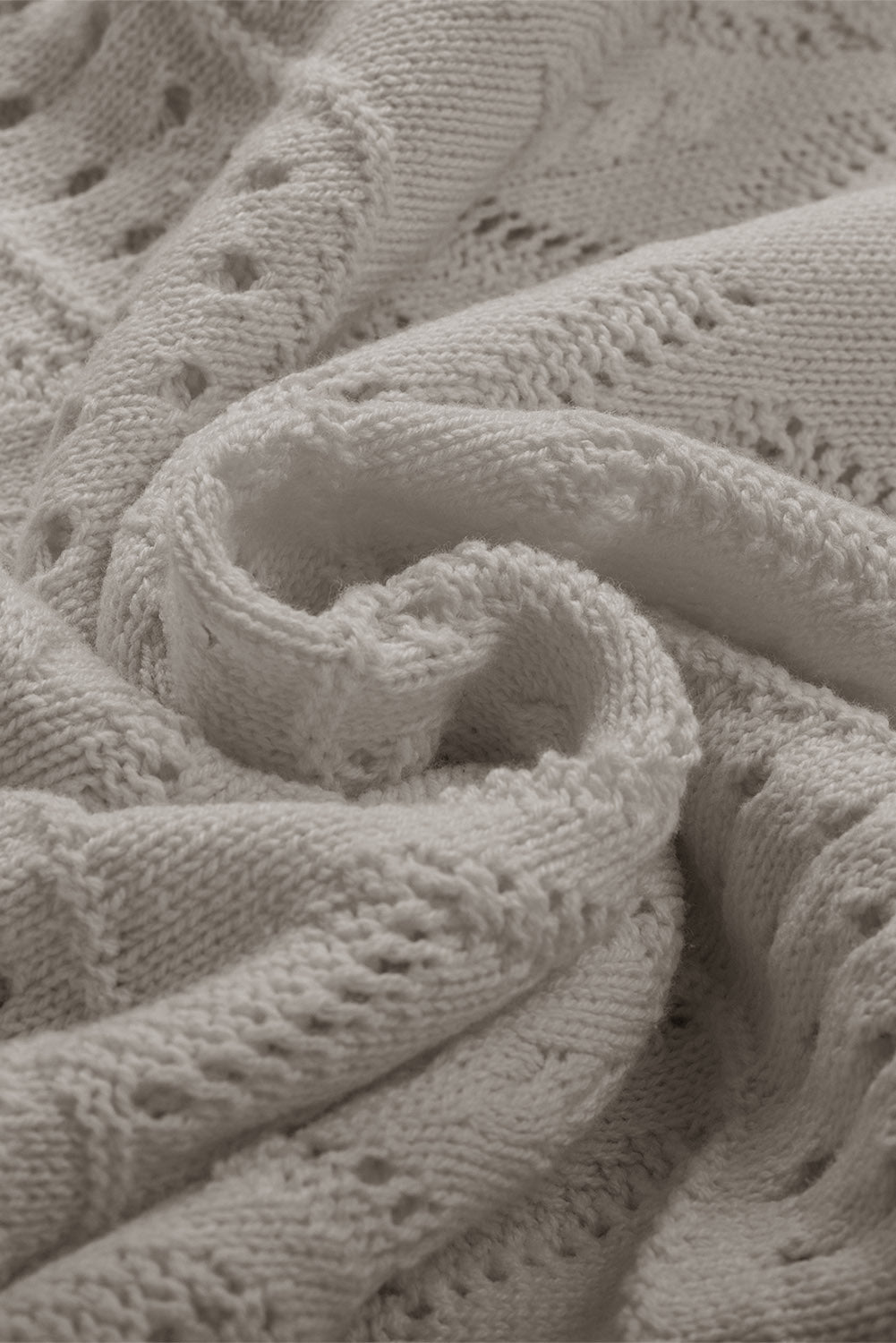 Gray openwork knit sweater with intricate stitch details and a soft texture.