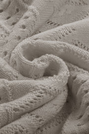 Gray openwork knit sweater with intricate stitch details and a soft texture.