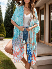 Bohemian patchwork print kimono in light blue with short sleeves and an open front, styled with denim shorts.
