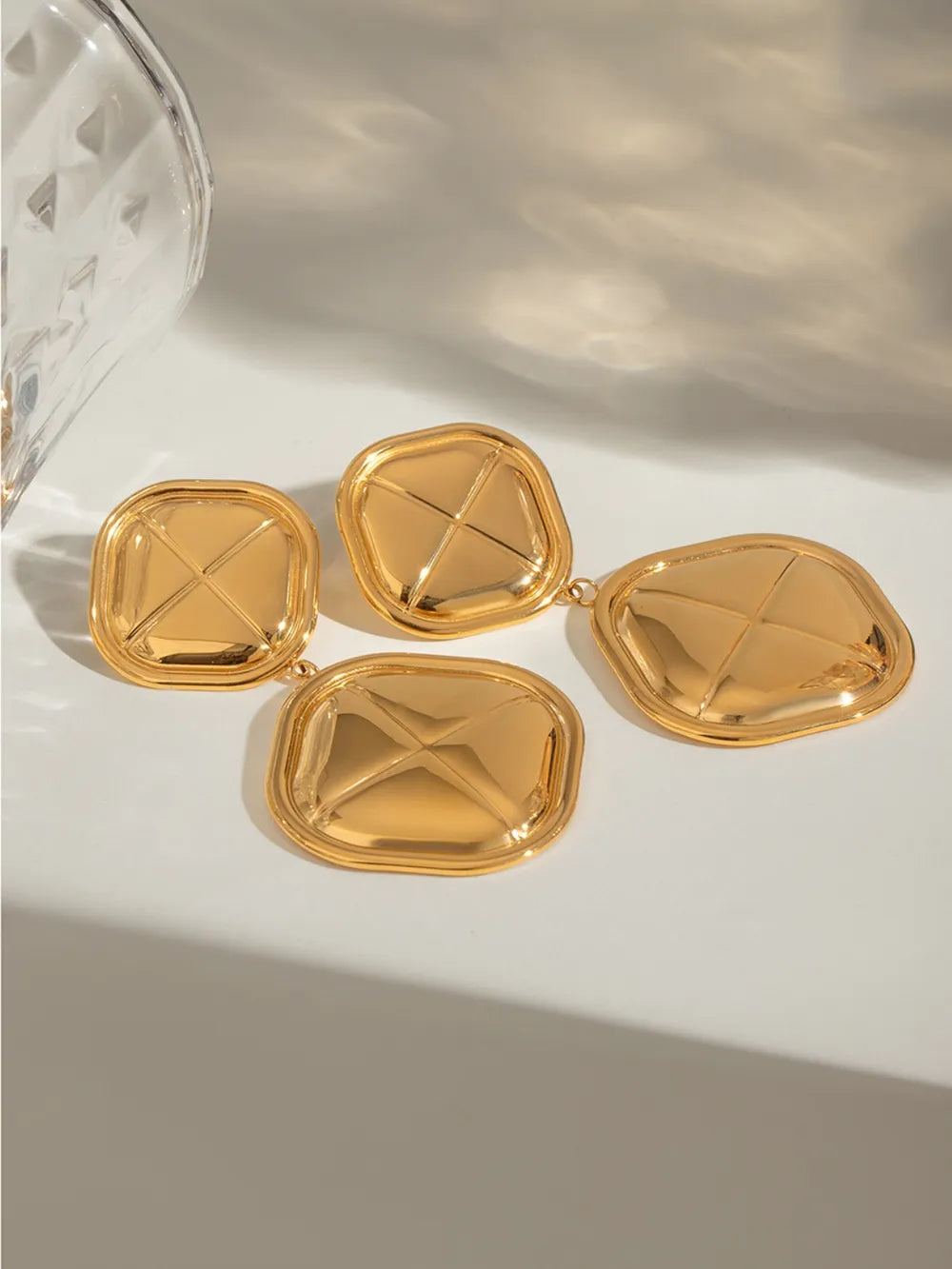 Gold 18K gold-plated drop earrings with sculpted geometric design and polished finish.
