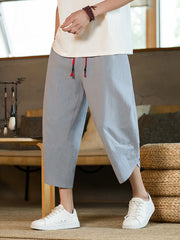 Men's light blue drawstring cropped sweatpants with red tie detail.