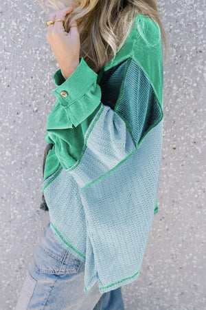 Panelled waffle knit blouson top in green and dusty blue with button cuff detail.