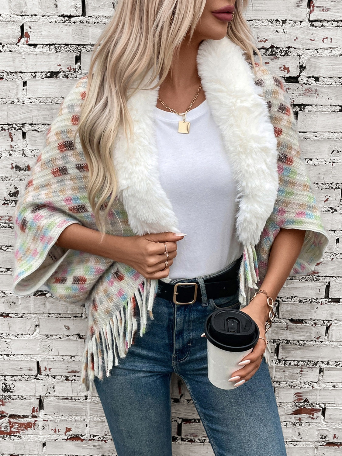 Textured plaid acrylic poncho with faux fur collar and fringe detail.