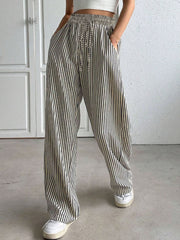 Wide-leg trousers in black and white vertical stripes with a drawstring waist and pockets.