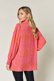 Orange and pink zebra print blouse with shirred cuffs and balloon sleeves.