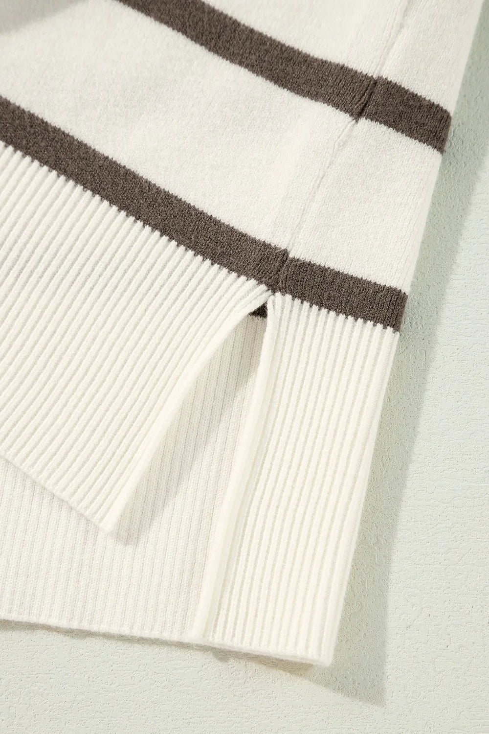 Striped knit top with cap sleeves and a slit hem detail.
