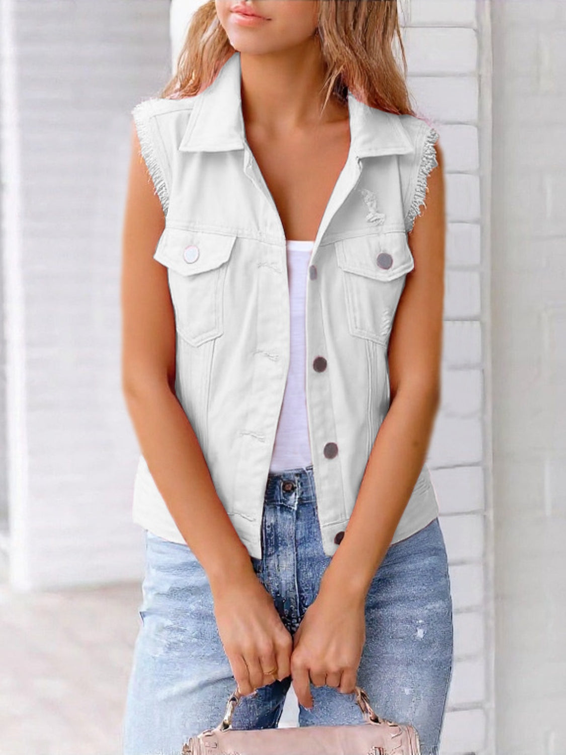 White denim vest with frayed shoulders and distressed details, collared, button front, sleeveless.