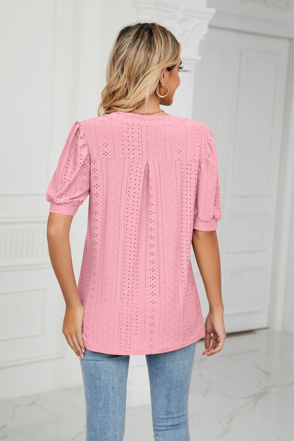 Pink perforated puff sleeve blouse with eyelet detail and a back pleat.