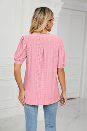 Pink perforated puff sleeve blouse with eyelet detail and a back pleat.