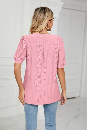 Pink perforated puff sleeve blouse with eyelet detail and a back pleat.