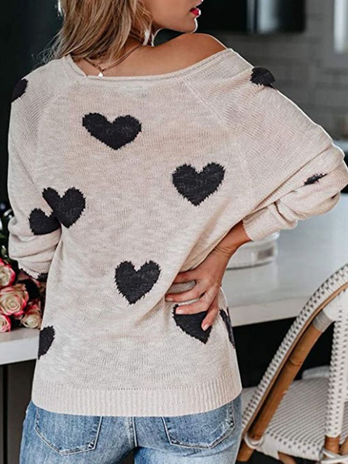 Eggshell raglan knit sweater with black heart motif, crew neck, and long sleeves.