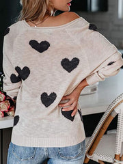 Eggshell raglan knit sweater with black heart motif, crew neck, and long sleeves.