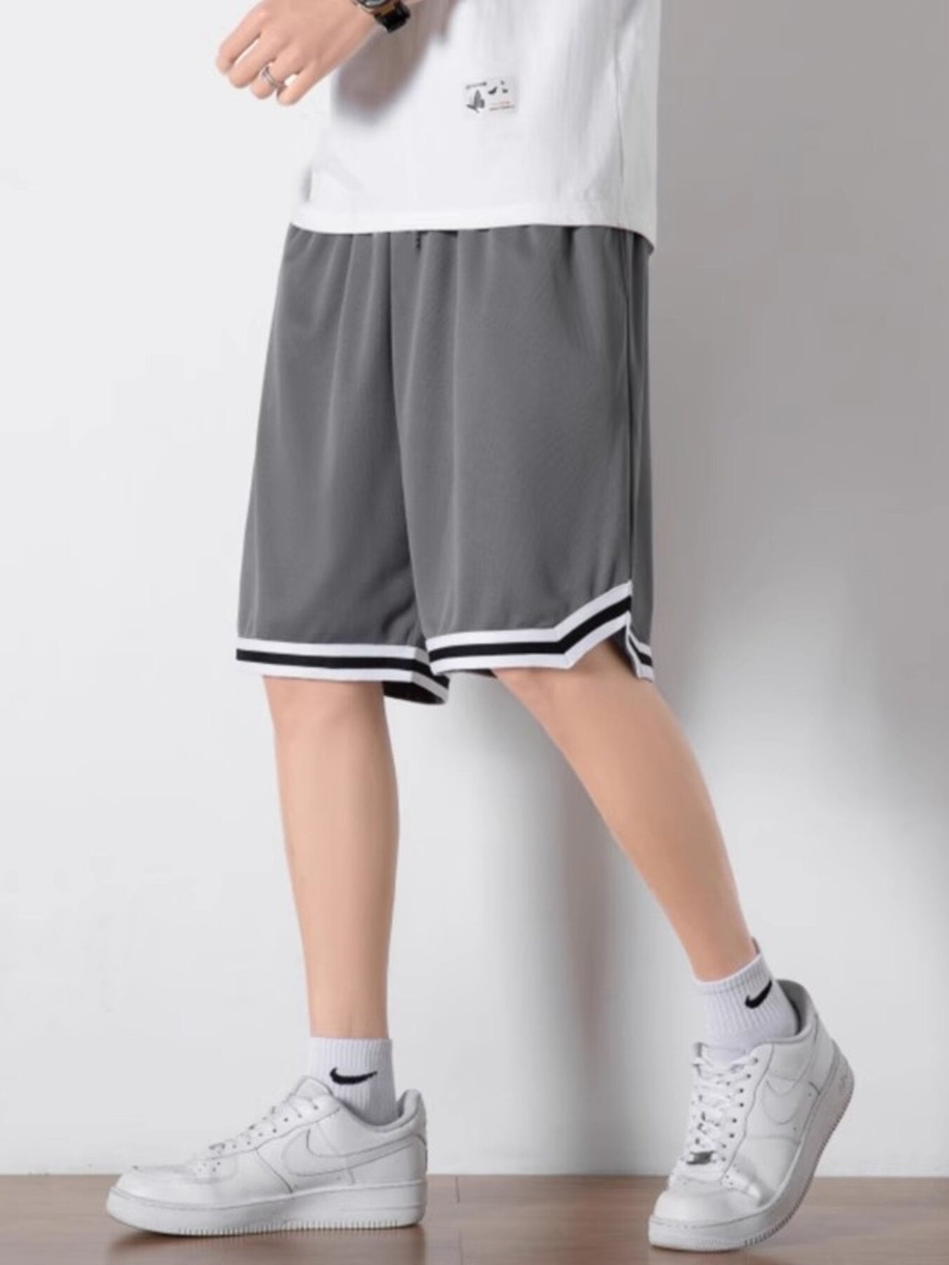Men's dark gray athletic shorts with white and black striped trim.