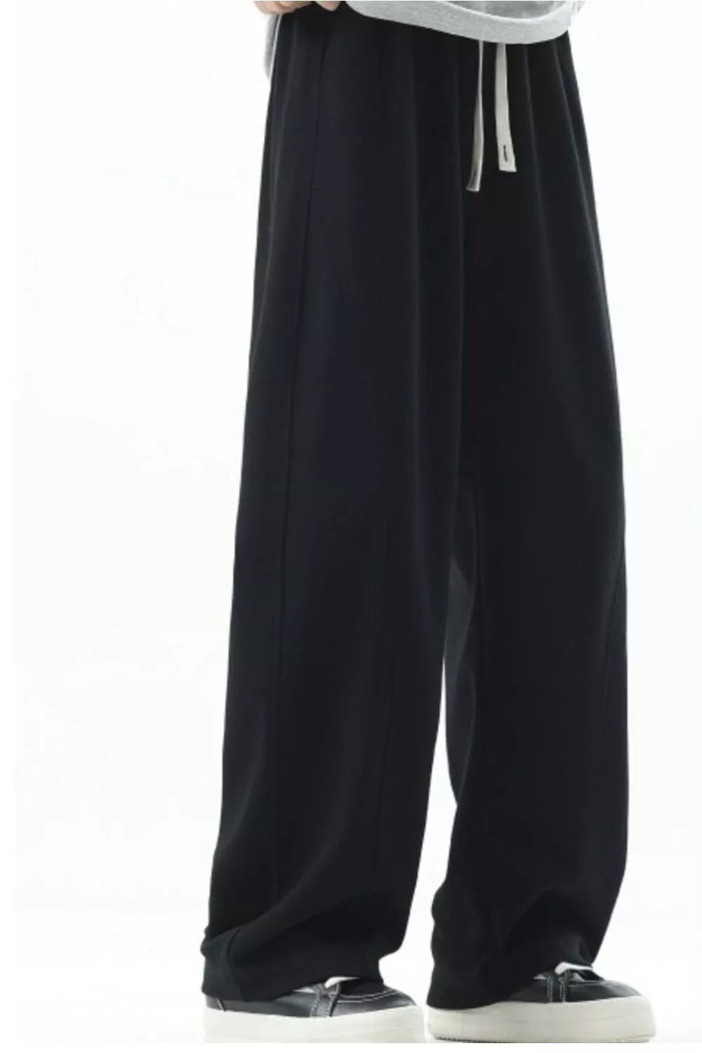 Men's black loose fit sweatpants with drawstring and white laces.