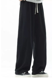 Men's black loose fit sweatpants with drawstring and white laces.