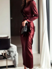 Burgundy satin maternity wrap dress with tie waist and long sleeves.