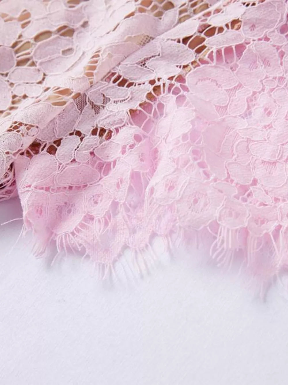 Powder floral lace dress detail with fringed hem.