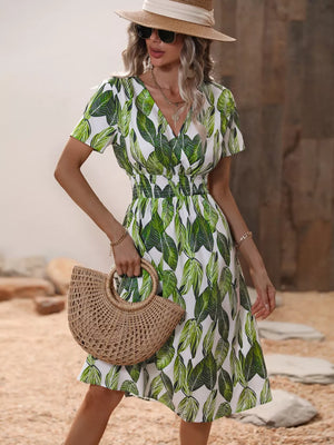 Vibrant leaf pattern midi dress with V-neck, short sleeves, and smocked waist.