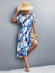 Blue abstract print midi dress with tie waist and short sleeves.