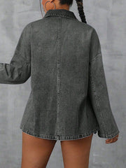 Oversized dark wash denim polo shirt with collared neckline and long sleeves.