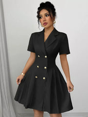 Black double-breasted pleated blazer dress with gold buttons and short sleeves.