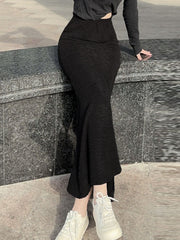 Black textured knit mermaid skirt with a flared hem, styled with white sneakers.