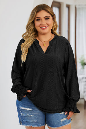 Black textured slit-neck blouse with shirred cuffs and long sleeves.