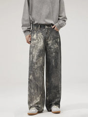 Dark gray wide-leg jeans with distressed paint splatter detail and a relaxed fit.