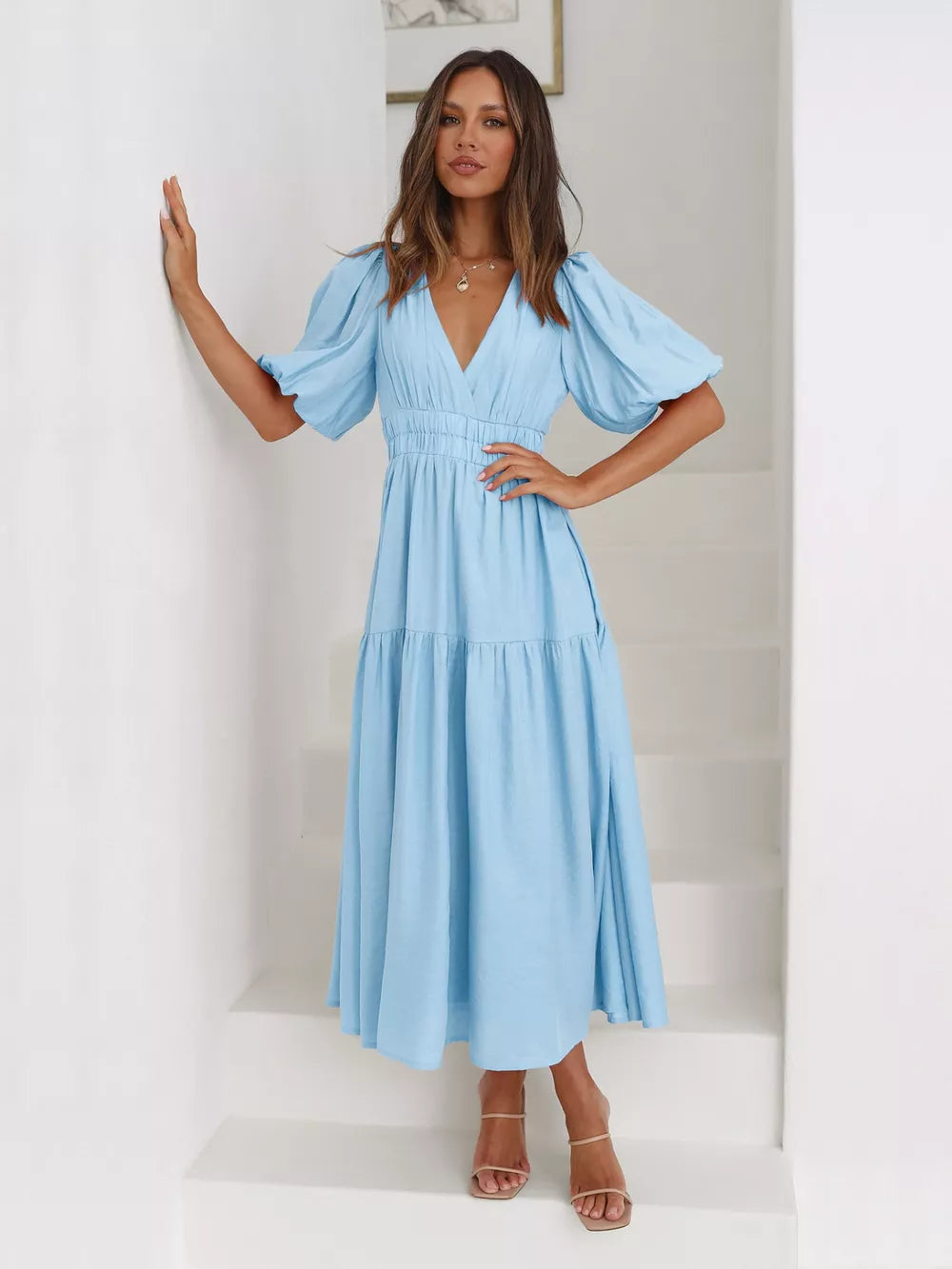 Pastel blue midi dress with puff sleeves, V-neck, and tiered skirt.