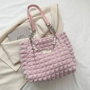 Blush pink textured grid shopper bag with pearl chain detail and chain straps.