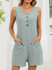 Sage buttoned sleeveless romper with textured fabric and patch pockets.
