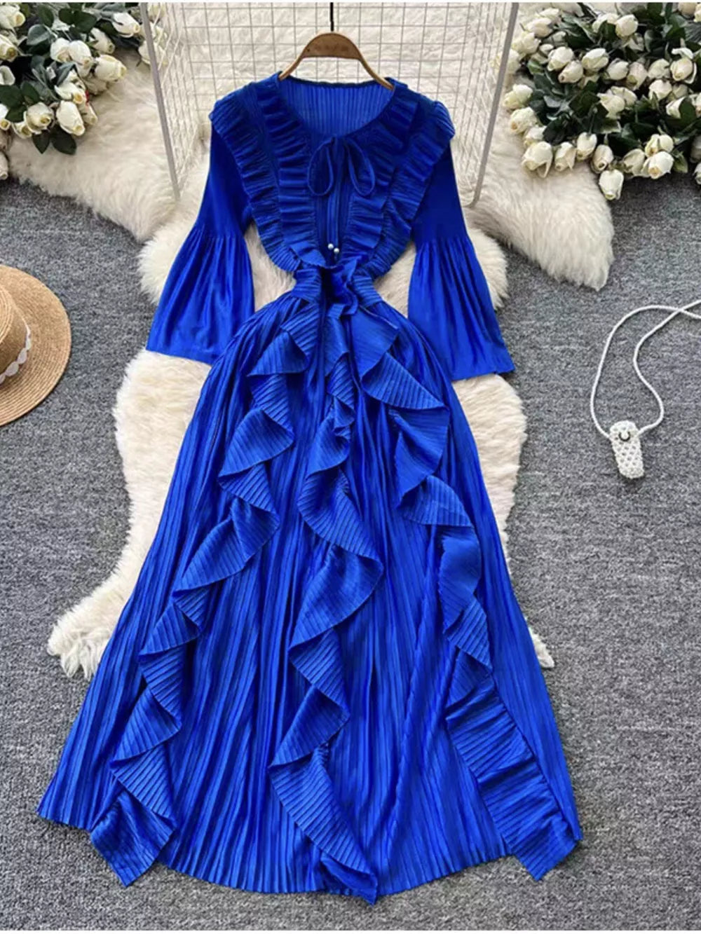 Royal blue A-line midi dress with cascading ruffles, tie neck, bell sleeves, and pleated skirt.