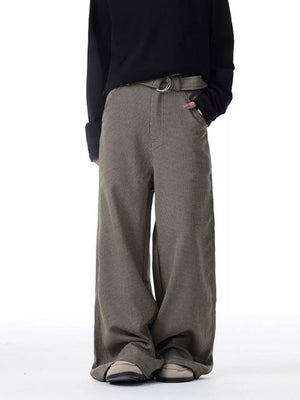 Men's wide-leg sweatpants in brown check with pockets and a belt.