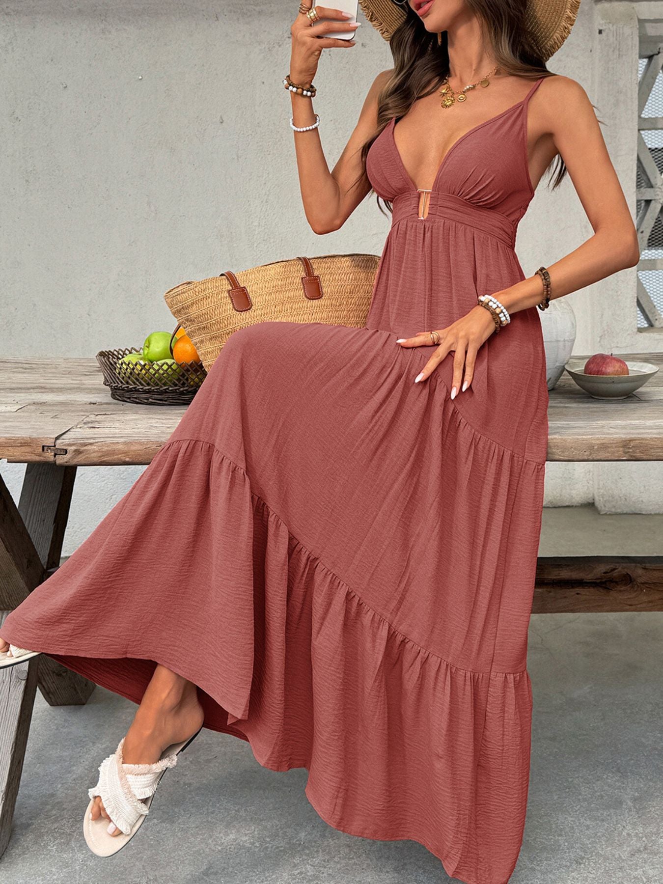Maxi dress with plunging V-neck, tiered ruffled hem, and adjustable straps in a rust color.