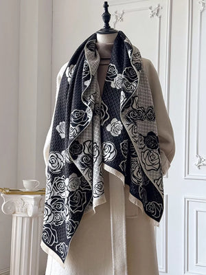 Black and white floral pattern scarf with fringed edges, displayed on a mannequin.