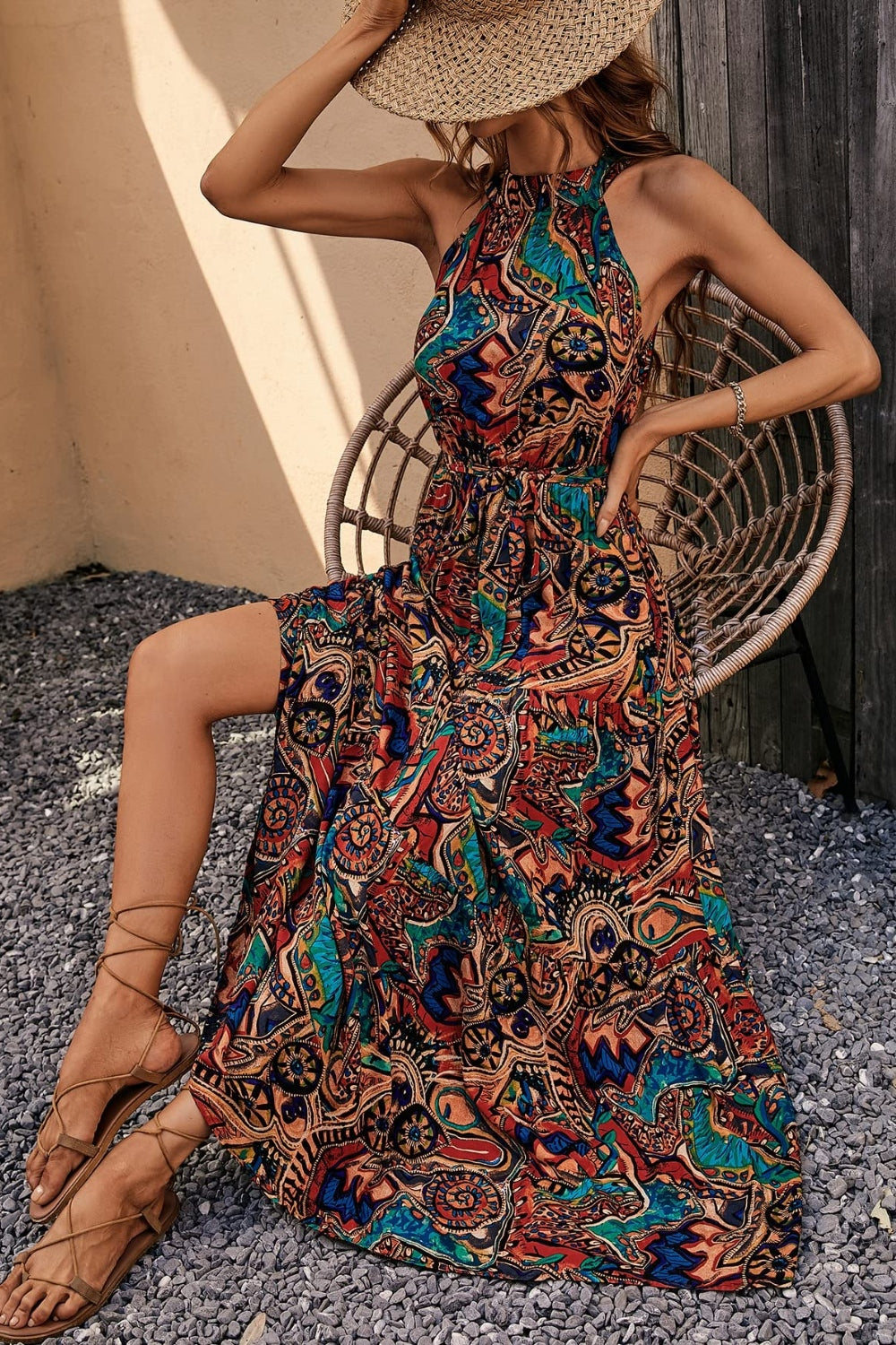 Halter neck maxi dress with paisley print in brown, green, blue, tan, and violet.