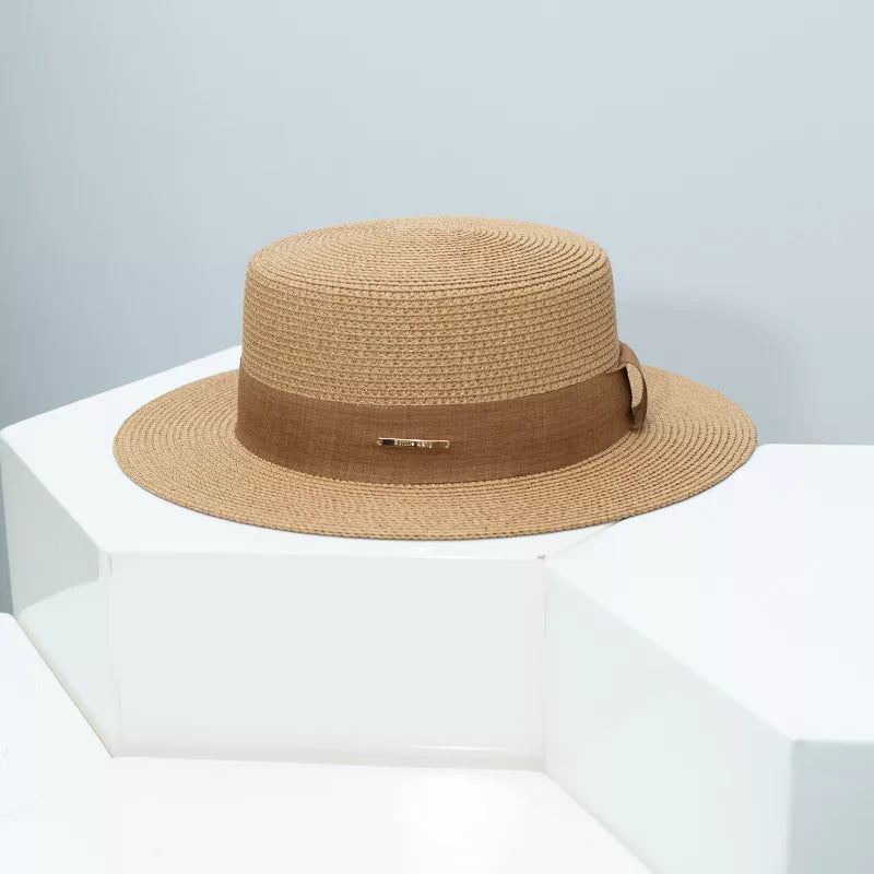 Woven straw boater hat in Khaki with a brown ribbon band and gold detail.