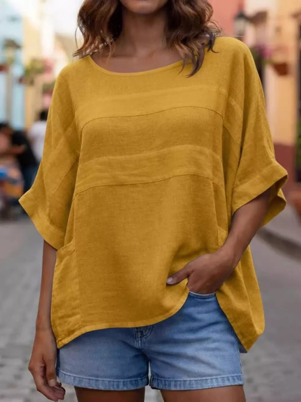 Yellow relaxed fit blouse with horizontal textured stripes and front pockets.
