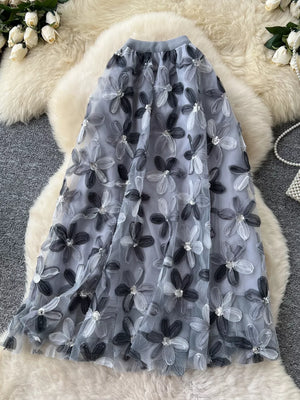 Gray layered midi skirt with embroidered floral appliques and sequin details.